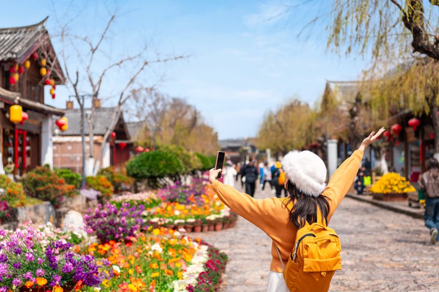 mujer con un gorro blanco en las calles con flores yunnan4