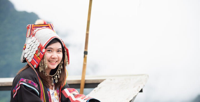 Mujer con vestimenta tradicional de una comunidad indígena del sudeste asiático en un mirador de montaña